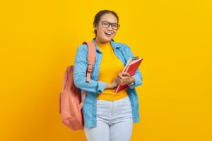 a woman with a backpack and a book smiling